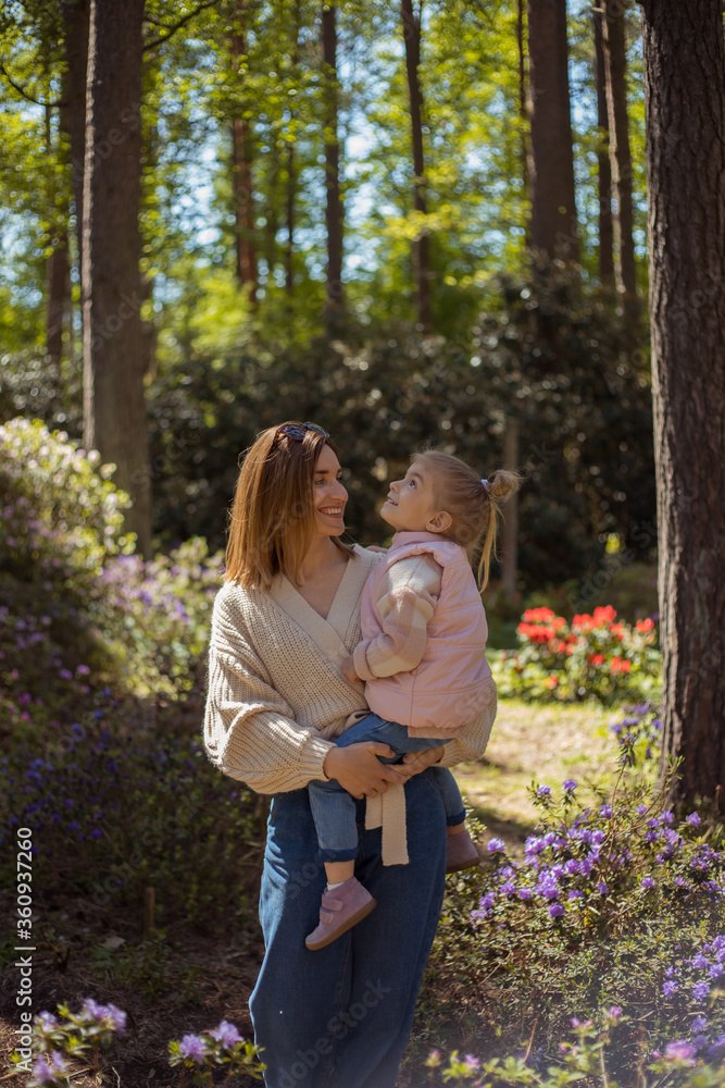Fototapeta premium Mother and daughter walking in rhododendron botanical garden.