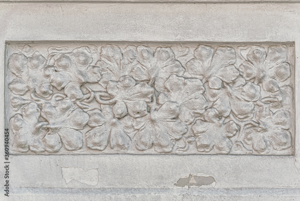 decorative stucco in a grape leaves form on an old house wall