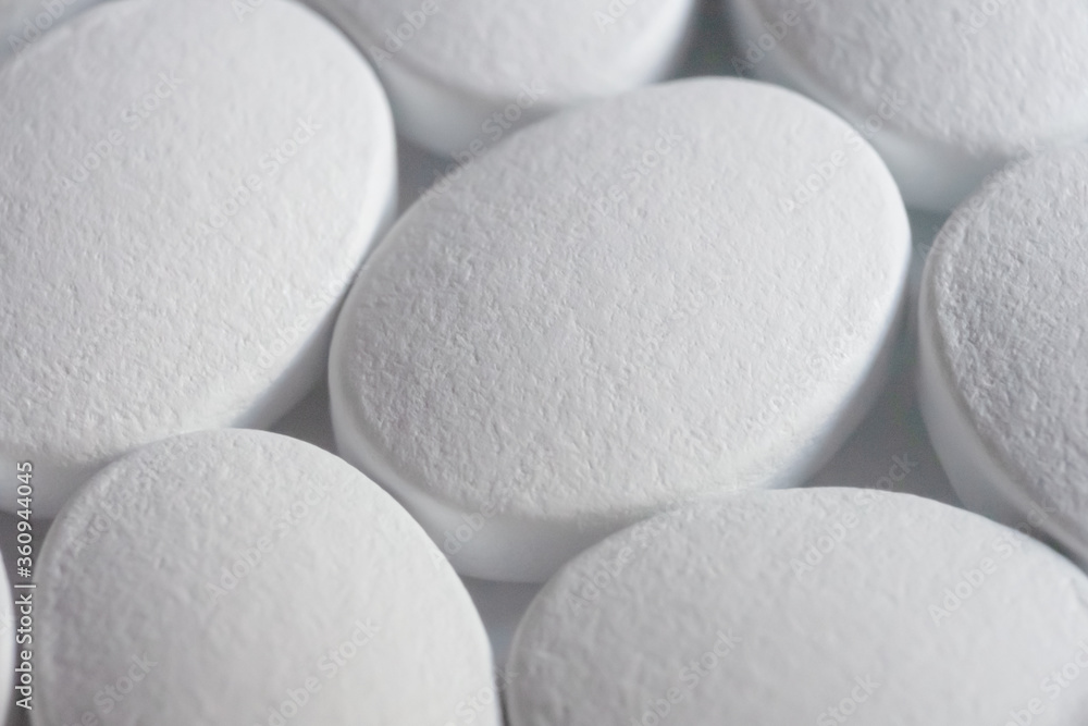 The textured rough surface of a water-soluble polymer coating of white tablets. Super macro. The textured rough surface of a water-soluble polymer coating of white tablets. Super macro.