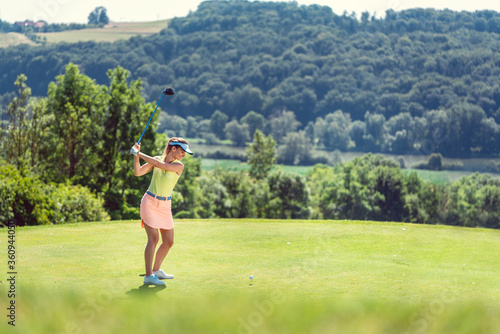 Beautiful woman playing golf on open course