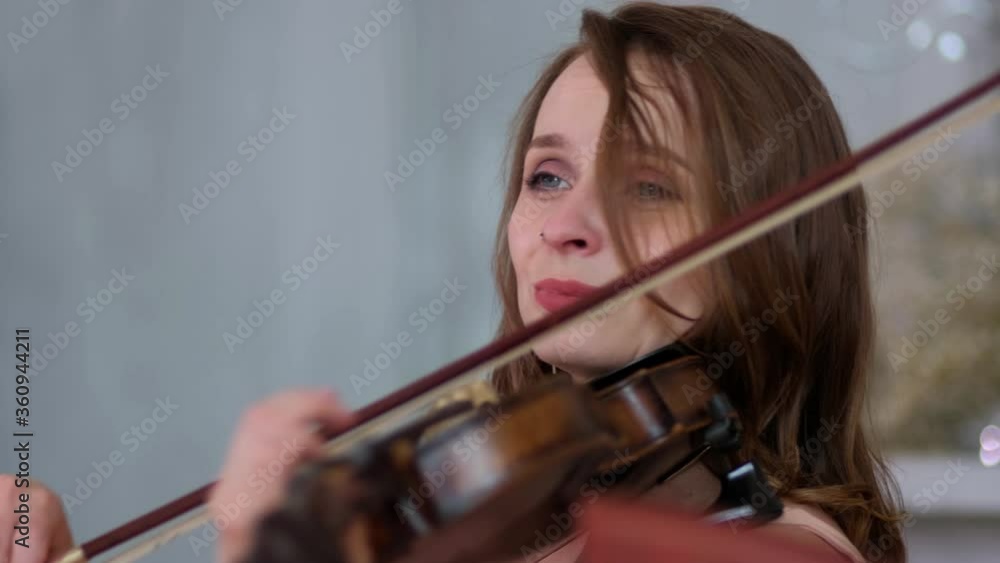 A beautiful violinist plays the violin. Close up A beautiful violinist plays the violin. Close up