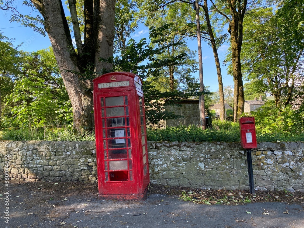 Old red telephone kiosk, with a postal box, in the centre of, Linton, Skipton, UK Old red telephone kiosk, with a postal box, in the centre of, Linton, Skipton, UK