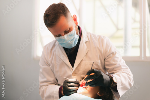dentist attending girl, care with instruments in clinic