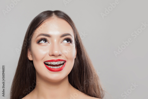 Smiling woman with braces on teeth on white, beautiful female face close up