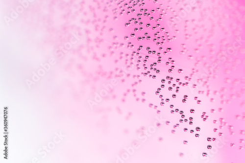 Fotografie Tiny bubbles on glass surface abstract pink background and copy space