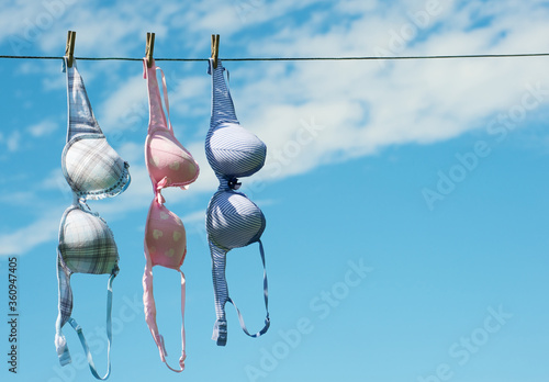 Three pretty bras hanging on the clothesline in the summer.