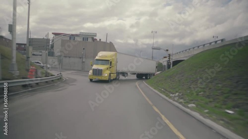 Montreal, QC, Canada - November 15, 2017: Semi trailer truck with yellow tractor unit while passing on underpass road then turning on the corner.