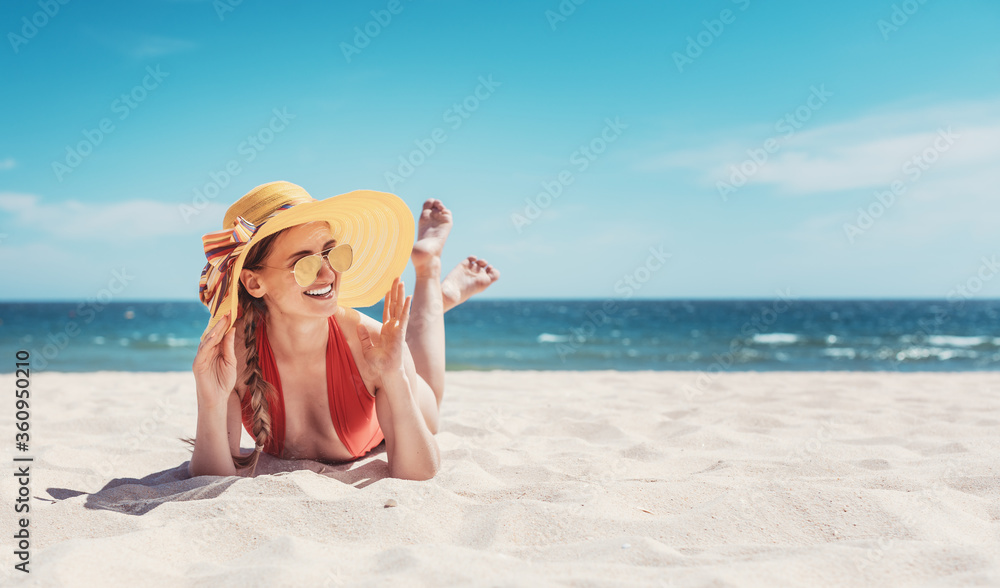 Woman enjoying her vacation by the sea tanning in the beach sand Woman enjoying her vacation by the sea tanning in the beach sand