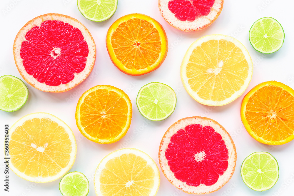 Various sliced citrus fruits: lime, orange, red and yellow grapefruit on a white background, texture.