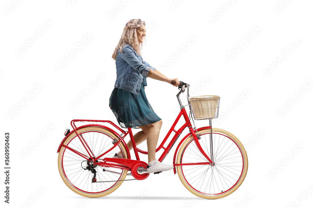 Blond young woman in a dress riding a red bicycle Blond young woman in a dress riding a red bicycle