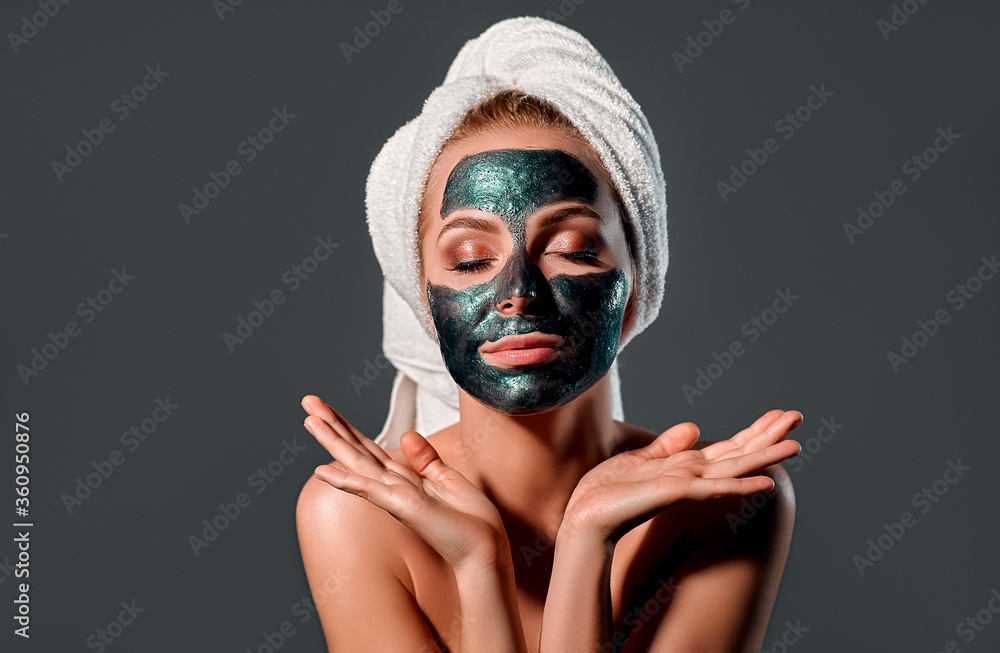 Beautiful woman with green peel-off mask on a gray background. Beautiful woman with green peel-off mask on a gray background.