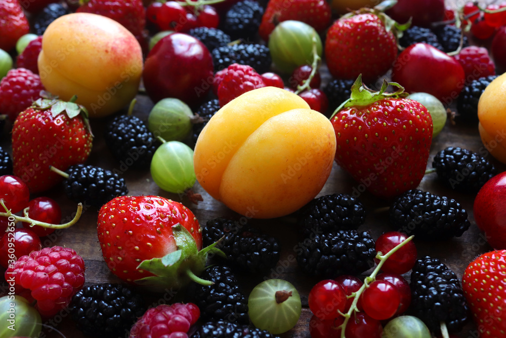 Juicy, fresh berry and fruit's background. Mix of strawberries, apricots. cherries, raspberries, red currants, mulberries, and gooseberries. Сlose up, selective focus. Summer concept Juicy, fresh berry and fruit's background. Mix of strawberries, apricots. cherries, raspberries, red currants, mulberries, and gooseberries. Сlose up, selective focus. Summer concept