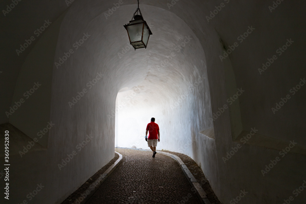 Homem em túnel com luz ao fundo do túnel 