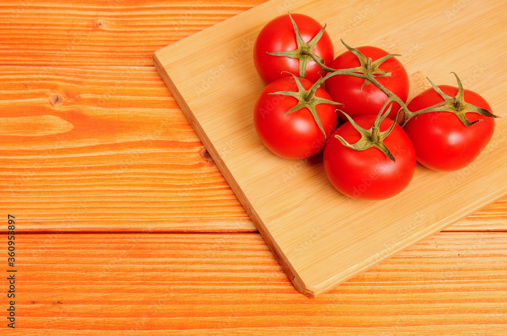 Red tomatoes on a wooden background Red tomatoes on a wooden background