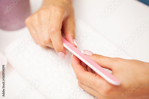 Nail care  woman with beautiful hands doing manicure in beauty studio