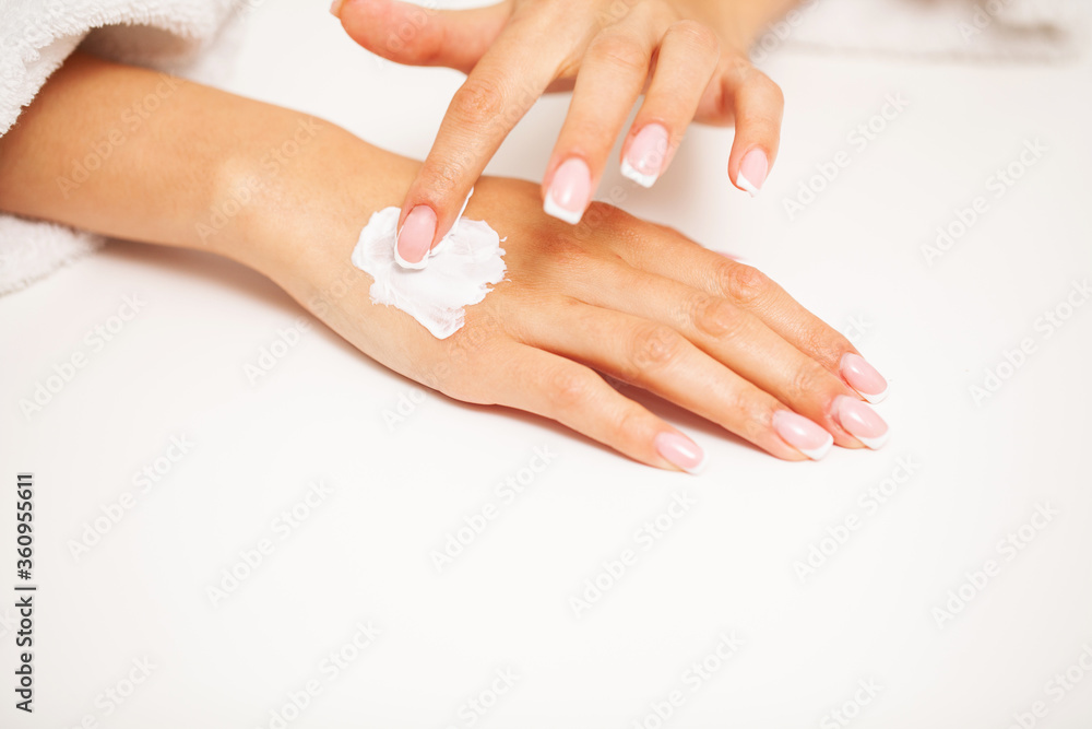 Naklejka premium Hand skin care, woman applies moisturizer on soft silky skin