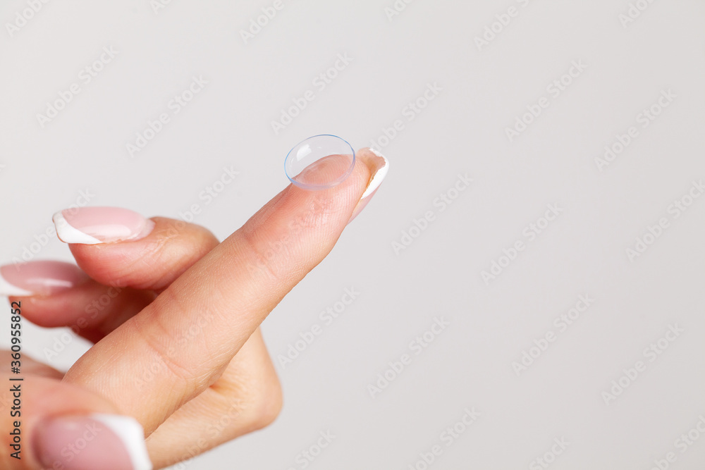 Solving vision problems, close up of woman holding contact lens Solving vision problems, close up of woman holding contact lens