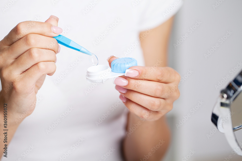 Vision problems, close up of woman holding container with contact lenses Vision problems, close up of woman holding container with contact lenses