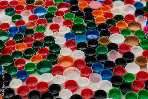 Close up of many colorful plastic bottle caps on white background. Stop plastic pollution concept