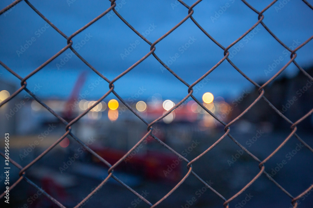 The metal mesh fence and the lights of the city. The metal mesh fence and the lights of the city.