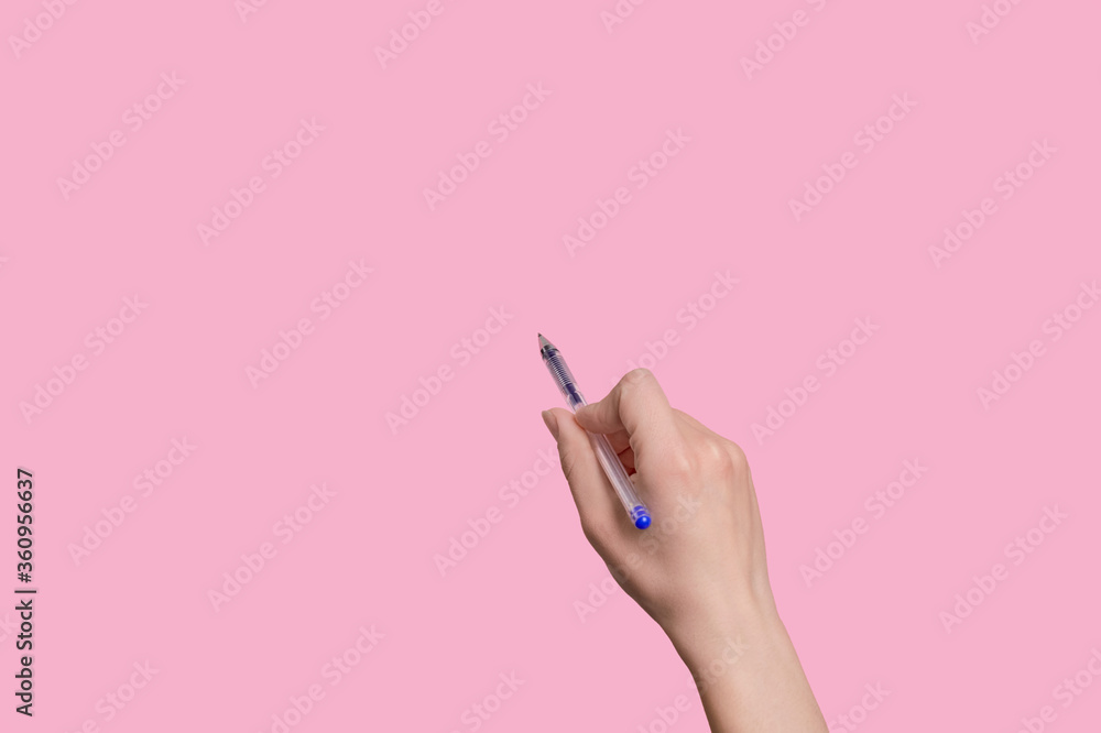 The girl holds a pen in her hand and writes something in the air. The girl holds a pen in her hand and writes something in the air.