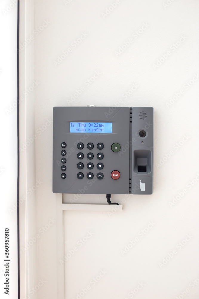 Small business biometric scanner. Electronic authorization equipment on the white wall, vertical orientation Small business biometric scanner. Electronic authorization equipment on the white wall, vertical orientation