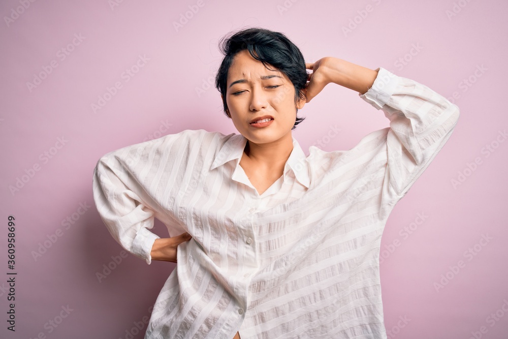 Young beautiful asian girl wearing casual shirt standing over isolated pink background stretching back, tired and relaxed, sleepy and yawning for early morning Young beautiful asian girl wearing casual shirt standing over isolated pink background stretching back, tired and relaxed, sleepy and yawning for early morning