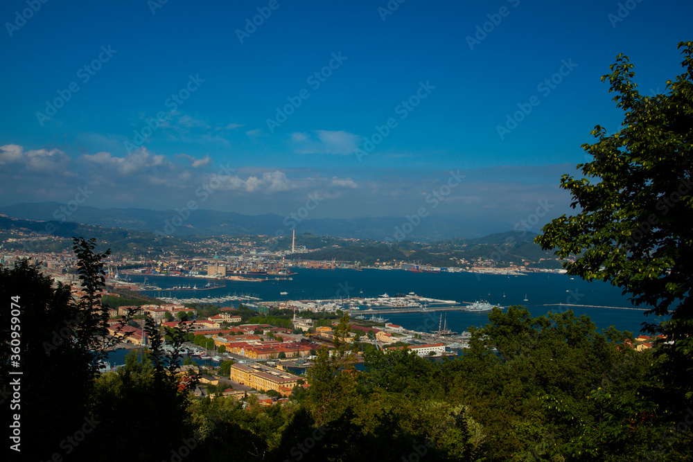 Aerial view of the northern Italian city of La Spezia, taken from a hilltop overlooking the city. Image shows port region with dockyard by the mediterranean sea as well as other coastal buildings. 