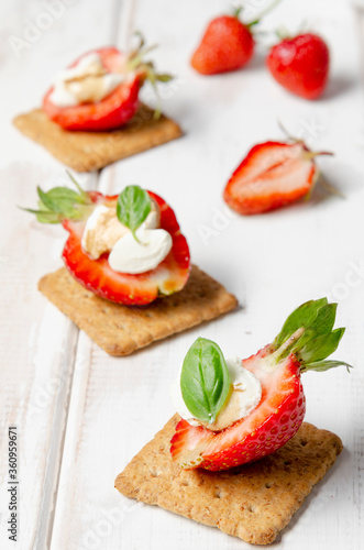 plate with fresh strawberry with cream cheese, balsamic vinegar and basil