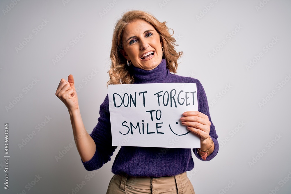 Middle age beautiful blonde woman holding banner funny positive message screaming proud and celebrating victory and success very excited, cheering emotion Middle age beautiful blonde woman holding banner funny positive message screaming proud and celebrating victory and success very excited, cheering emotion