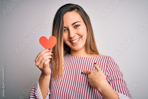 Schilderij op canvas Young beautiful blonde romantic woman holding red paper heart over white backgro