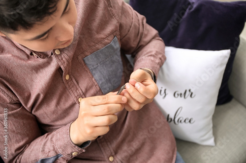 Young Asian man doing manicure at home
