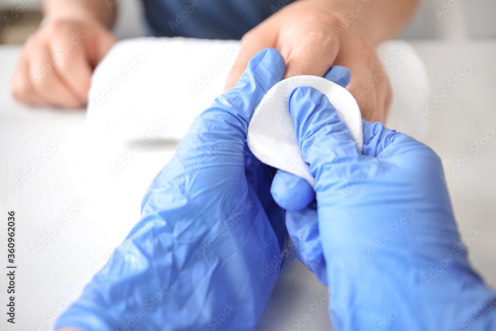 Fototapeta premium Manicure master working with male client in beauty salon, closeup