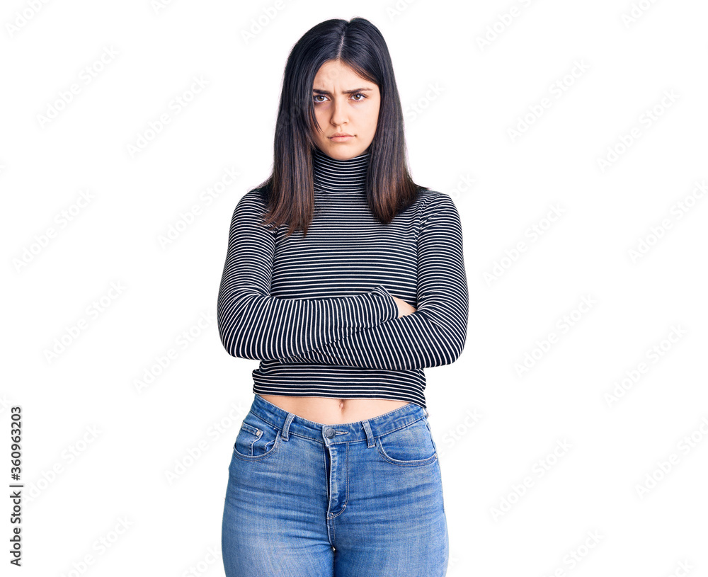 Young beautiful girl wearing striped t shirt skeptic and nervous, disapproving expression on face with crossed arms. negative person. Young beautiful girl wearing striped t shirt skeptic and nervous, disapproving expression on face with crossed arms. negative person.
