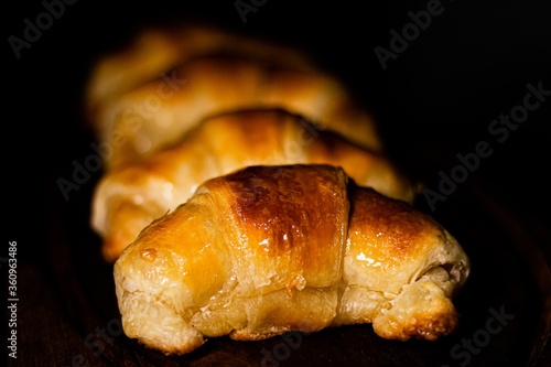 Closeup shot of delicious croissants in a row under the light with a blurry background photo