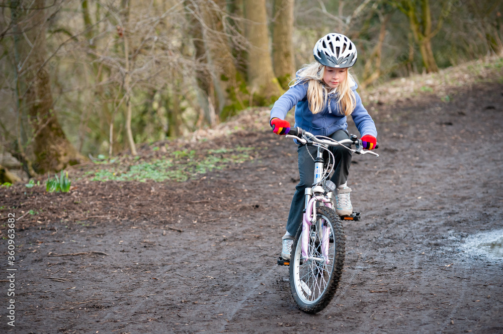 A young girl riding a bike along a country track