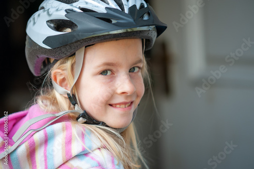 Close up of a smiling young blonde girl in a cycle helmet © dave