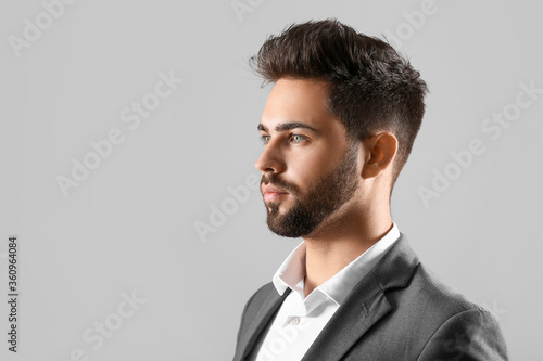 Handsome man with stylish hairdo on grey background
