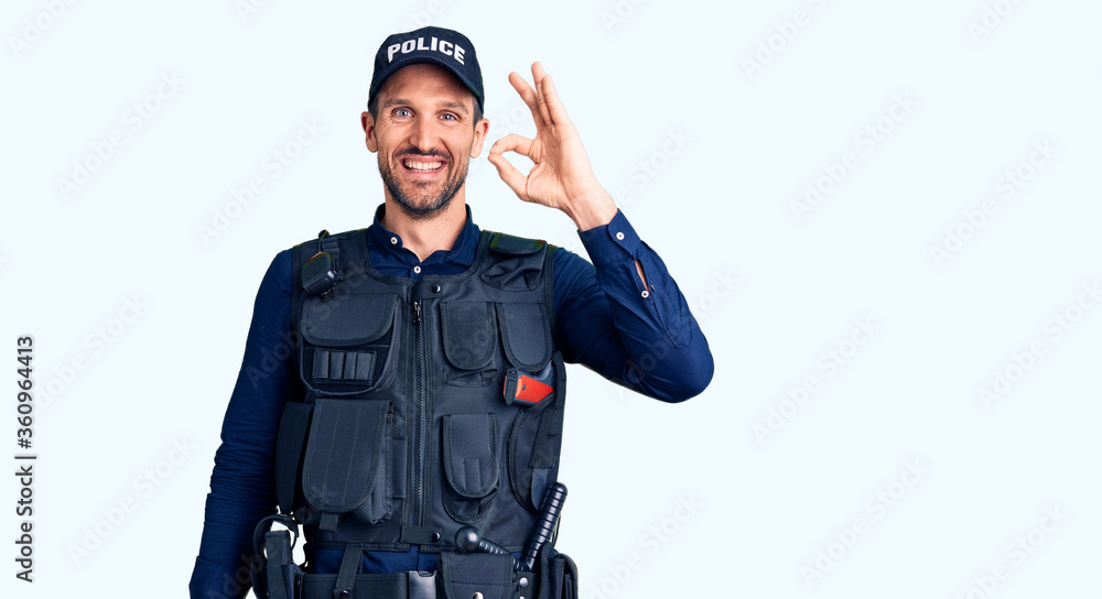 Young handsome man wearing police uniform smiling positive doing ok sign with hand and fingers. successful expression. Young handsome man wearing police uniform smiling positive doing ok sign with hand and fingers. successful expression.