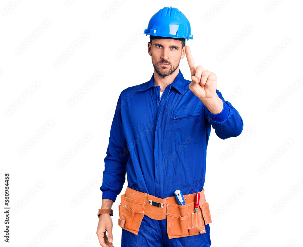 Young handsome man wearing worker uniform and hardhat rejection expression crossing arms doing negative sign, angry face Young handsome man wearing worker uniform and hardhat rejection expression crossing arms doing negative sign, angry face