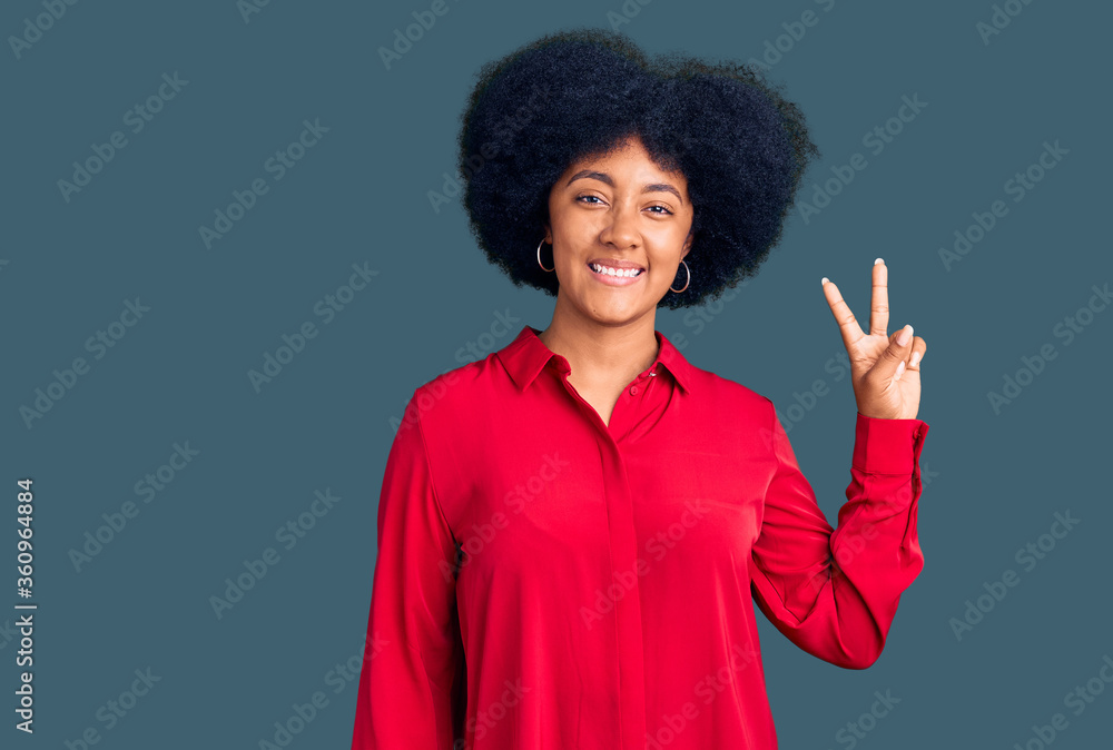 Young african american girl wearing casual clothes smiling looking to the camera showing fingers doing victory sign. number two. Young african american girl wearing casual clothes smiling looking to the camera showing fingers doing victory sign. number two.