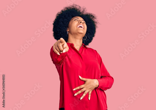 Young african american girl wearing casual clothes laughing at you, pointing finger to the camera with hand over body, shame expression