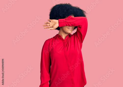 Young african american girl wearing casual clothes covering eyes with arm, looking serious and sad. sightless, hiding and rejection concept © Krakenimages.com