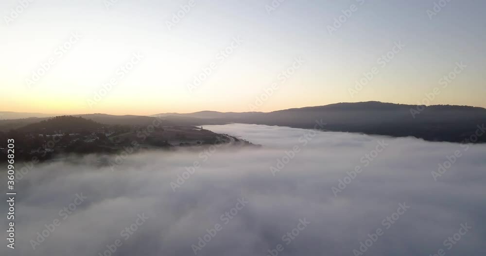 Misty mountain Valley filled with fog clouds during sunrise with golden gradient sky camera turning left fast Misty mountain Valley filled with fog clouds during sunrise with golden gradient sky camera turning left fast