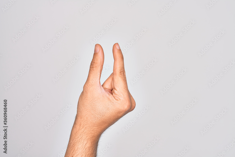 Hand of caucasian young man showing fingers over isolated white background picking and taking invisible thing, holding object with fingers showing space Hand of caucasian young man showing fingers over isolated white background picking and taking invisible thing, holding object with fingers showing space