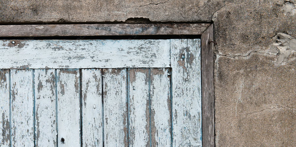 Old wooden plank door with concrete wall