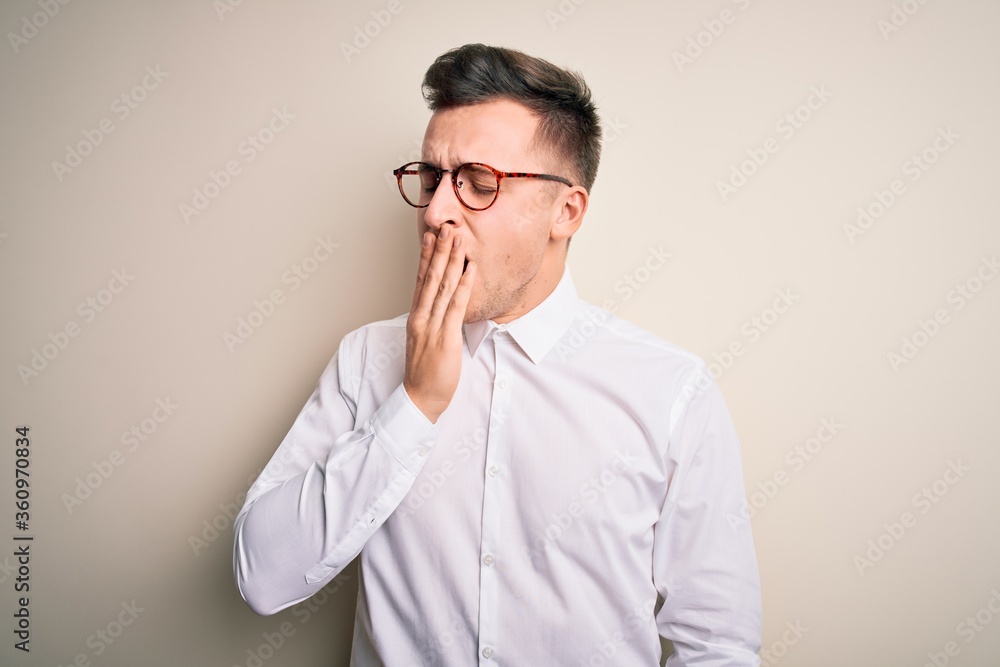 Young handsome business mas wearing glasses and elegant shirt over isolated background bored yawning tired covering mouth with hand. Restless and sleepiness. Young handsome business mas wearing glasses and elegant shirt over isolated background bored yawning tired covering mouth with hand. Restless and sleepiness.
