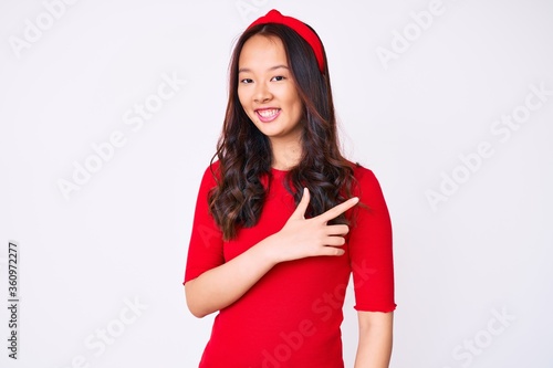 Young beautiful chinese girl wearing casual clothes smiling cheerful pointing with hand and finger up to the side