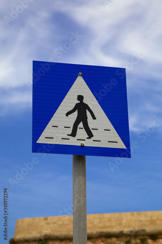 Road sign pedestrian crossing on a blue sky background