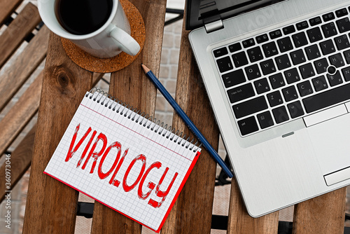 Writing note showing Virology. Business concept for branch of science dealing with the variety of viral agents and disease Workplace overview with laptop used for individual interest photo